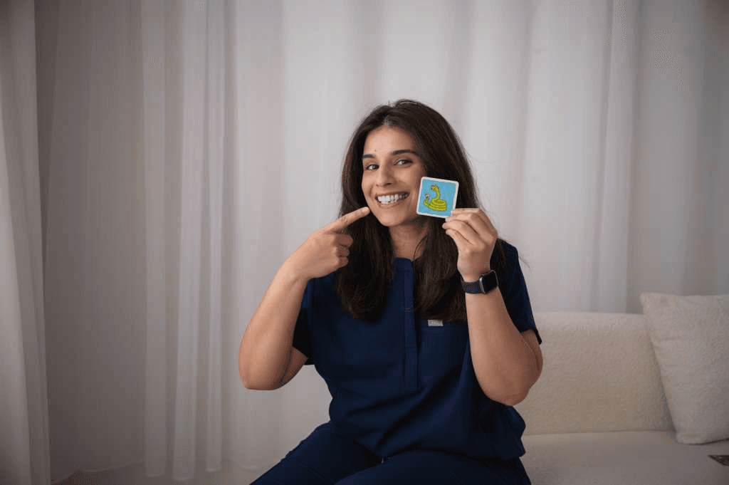 Verda demonstrating speech sounds with a flashcard during pediatric therapy